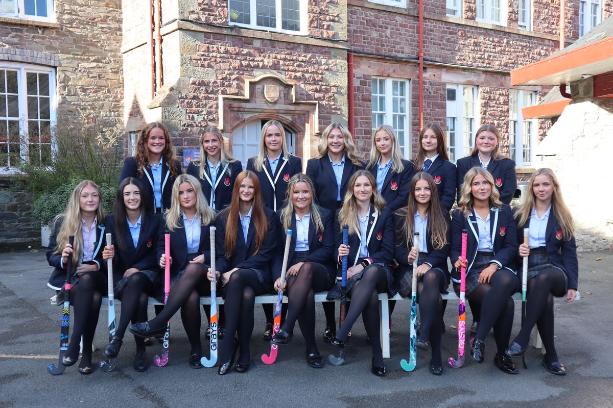 The 1st XI hockey team in College blazers, seated and standing in two rows with their sticks